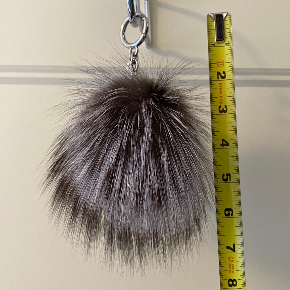Beautiful Michael Kors keychain Pom in gray with white tones and black tips.